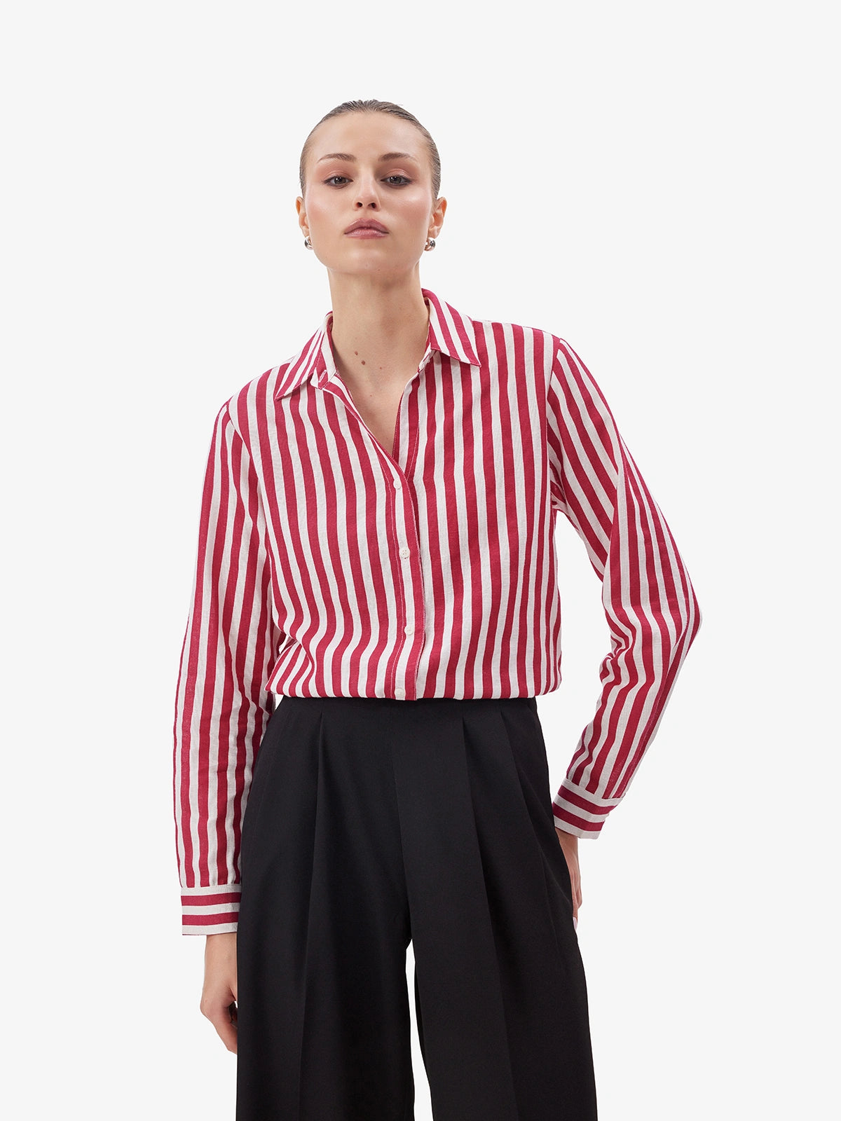 Person wearing a red and white striped shirt with black pants on a white background
