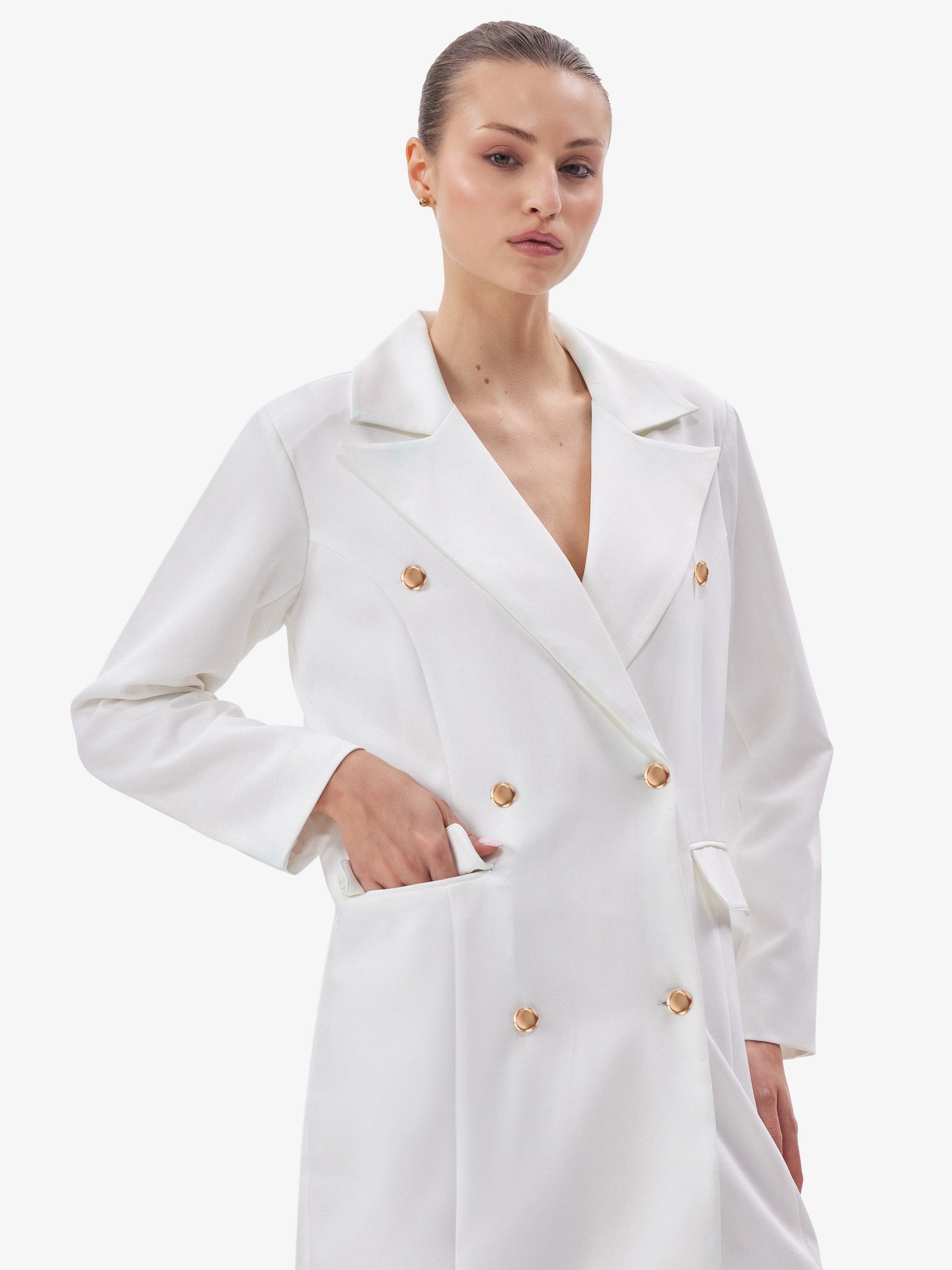 Woman wearing a white coat with gold buttons on a white background