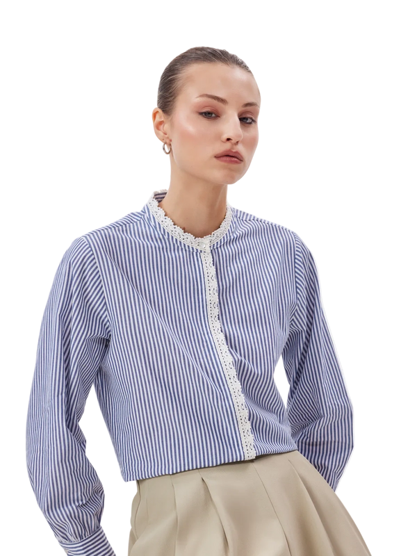 Woman wearing a blue and white striped shirt with lace details on a white background