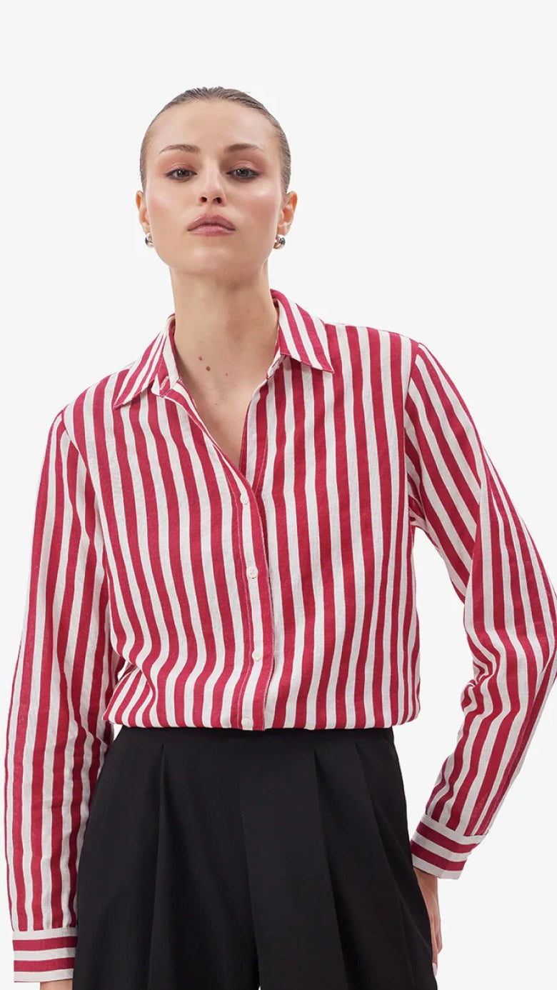 Person wearing a red and white striped shirt with a plain background