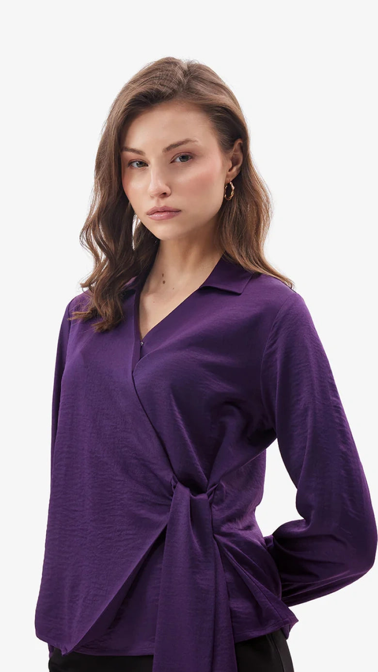 Woman wearing a purple long-sleeve top on a white background